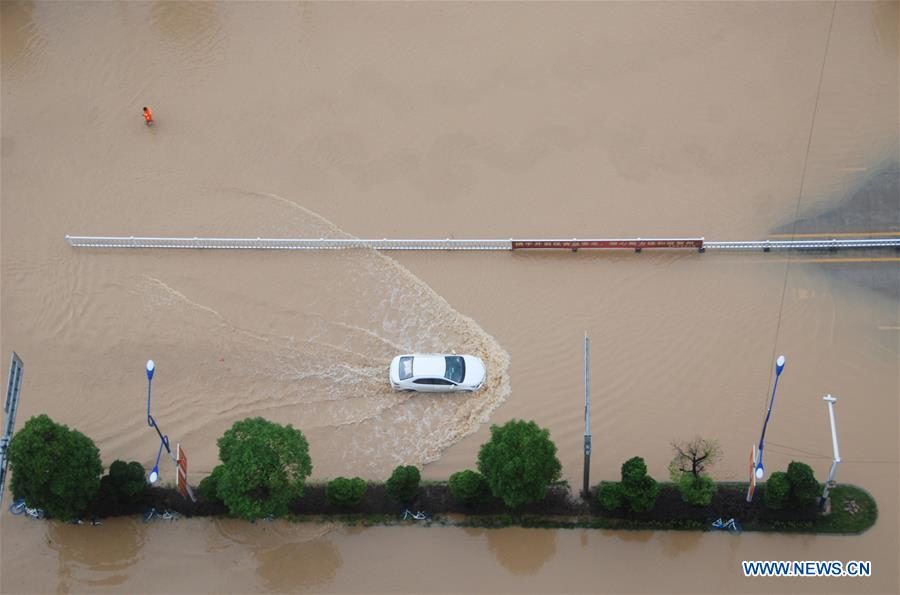 A vehicle makes its way through a flooded road in Hezhou, south China's Guangxi Zhuang Autonomous Region, June 7, 2020.