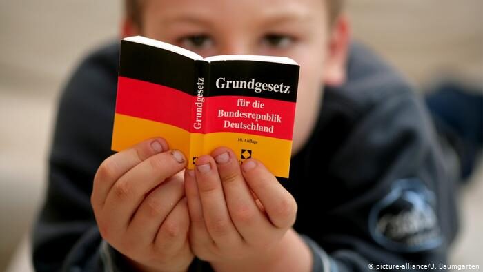 child reads basic German Basic Law