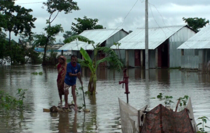 People use makeshift raft as transport during the flood in Sunamganj