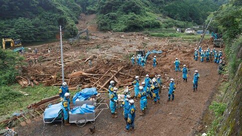 Rescuers search for missing people at the site of a mudslide caused by heavy rain in Natsugi town in Kumamoto prefecture, southwestern Japan, on Sunday, July 5, 2020.