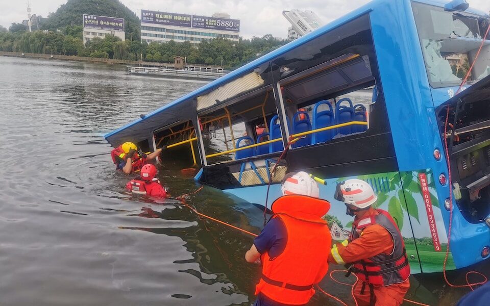 Rescue workers are seen at the site where a bus carrying students plunged into a lake