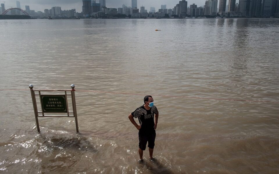 Click to enlarge A man standing on a flooded street on the banks of the Yangtze River after heavy rain in Wuhan in China's central Hubei province