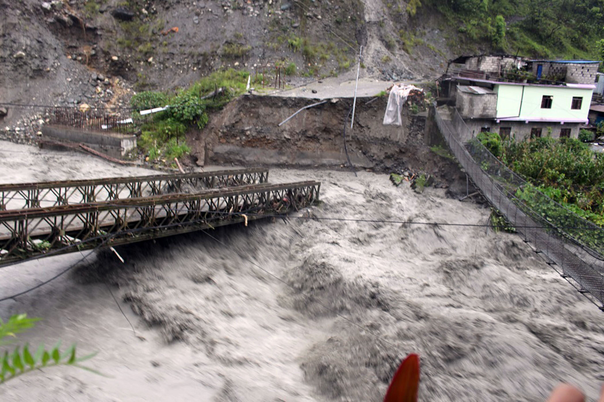 Rainfall-triggered flood damages a bridge at Raghuganga River in Myagdi district.