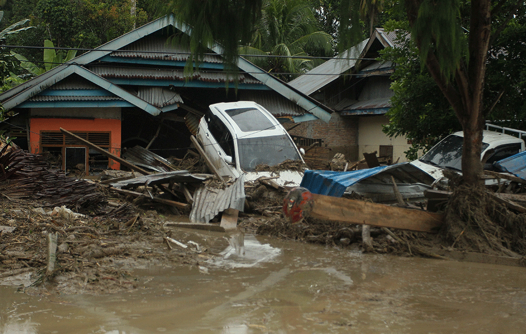 A general view shows vehicles swept away by flash floods next to houses in Radda village in North Luwu regency, South Sulawesi on July 14, 2020