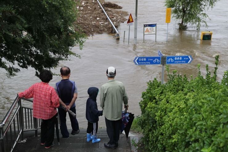 A flooded stream in Daejeon has stopped passers-by as the city saw downpour on Monday that continued from a day before.