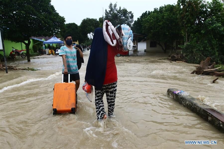Residents wade through flood water