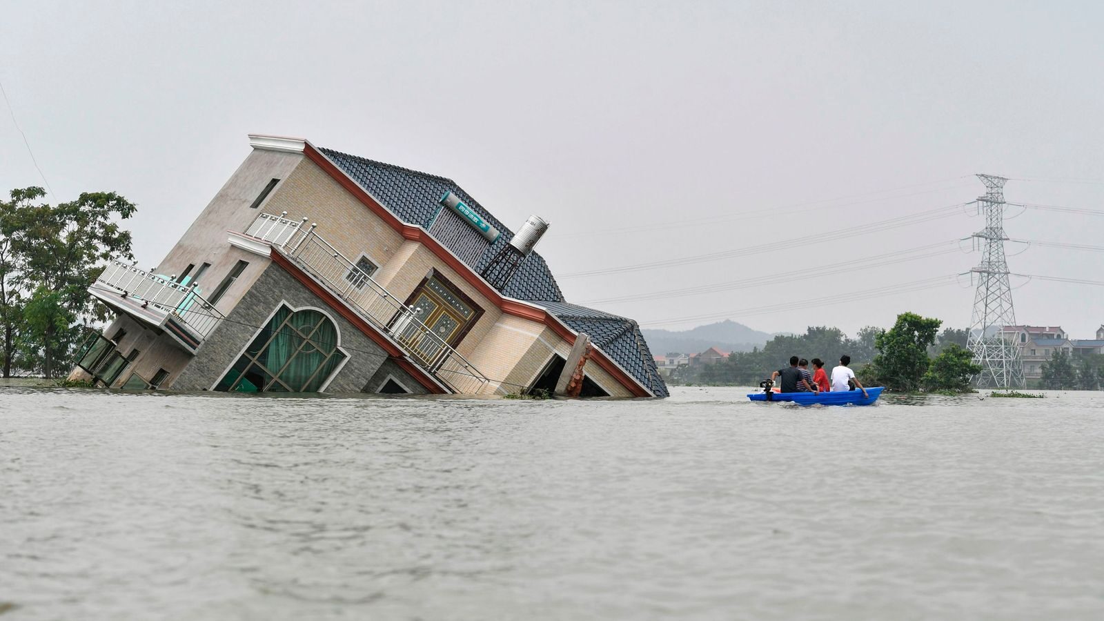 Click to enlarge A house topples over due to the flooding in China's central Jiangxi province