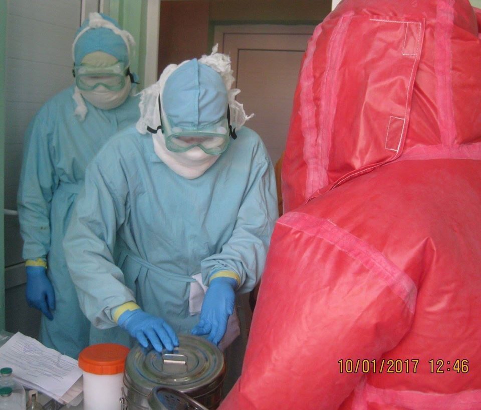 Click to enlarge Biologists in protective gear at the Central Reference Laboratory