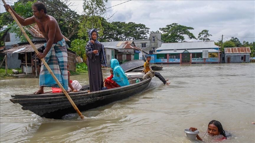 People ride on boat in flooded area after heavy monsoon rains in Dohar near Dhaka, Bangladesh on July 24, 2020.