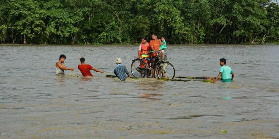 Villagers on a banana raft move to a safer place from the flooded area of Goalbil in Baksa district of Assam.