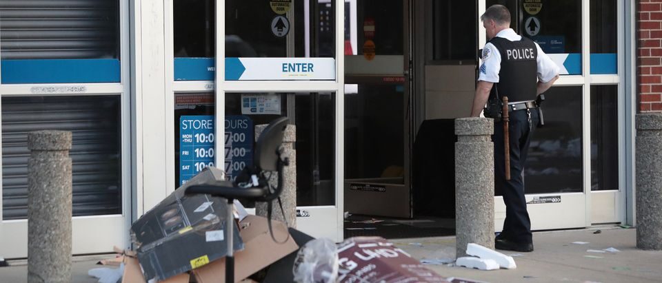 Click to enlarge officer outside of looted Best Buy store