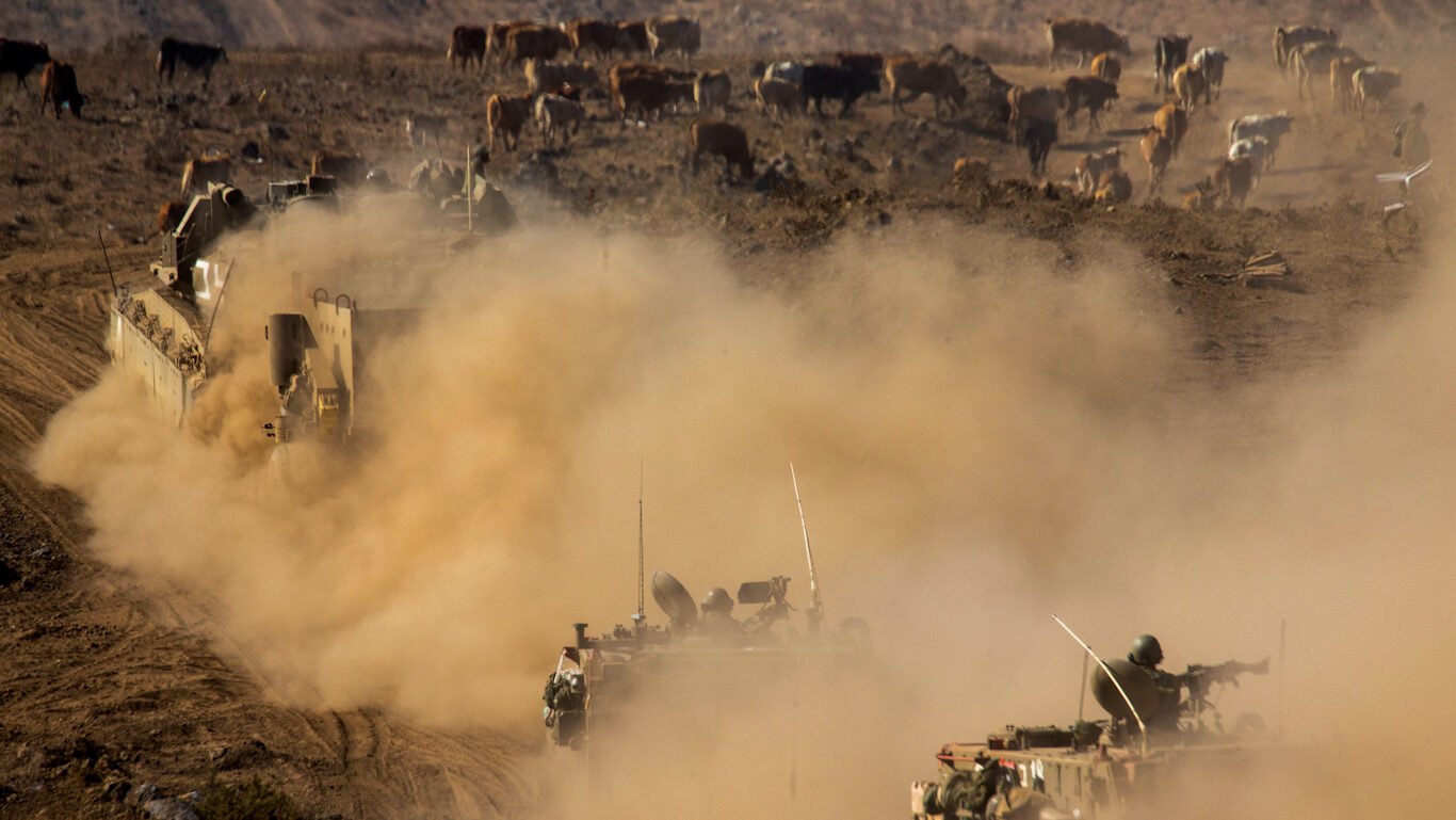 Click to enlarge Israeli soldiers drive military vehicles