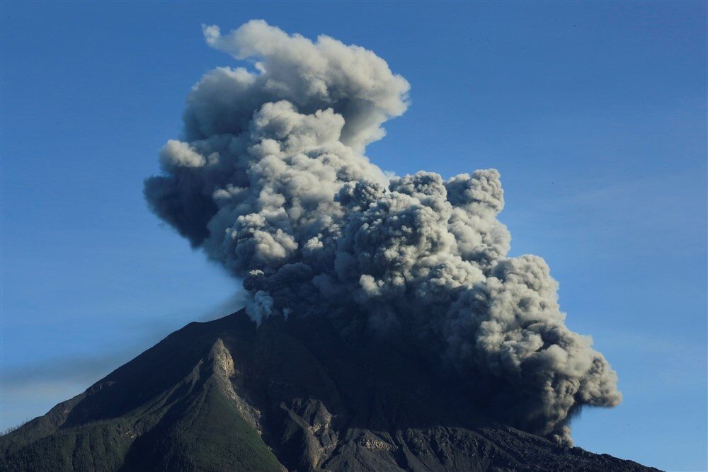 Click to enlarge Mount Sinabung volcano spews volcanic material as seen from Tiga Pancur village in Karo, North Sumatra province in Indonesia on Sunday.