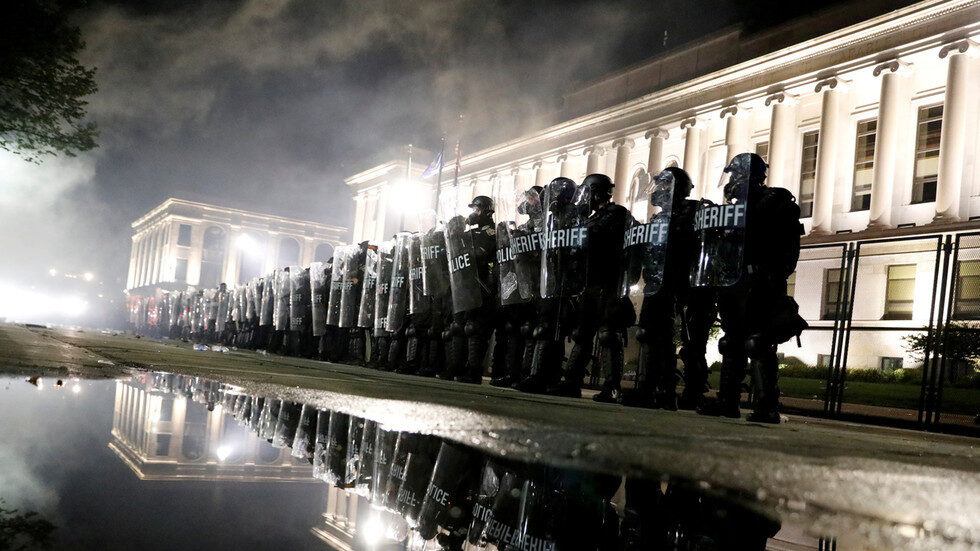 Riot police stand guard during a protest