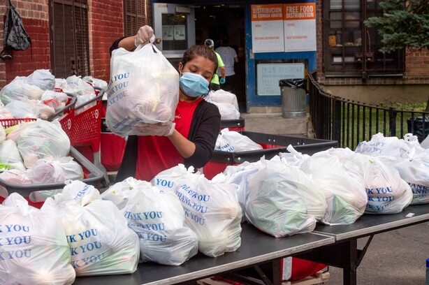 A volunteer prepares food from the La Jornada food pantry.