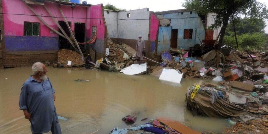 Local residents examine their damaged house caused by heavy monsoon rains, in Yar Mohammad village near Karachi.