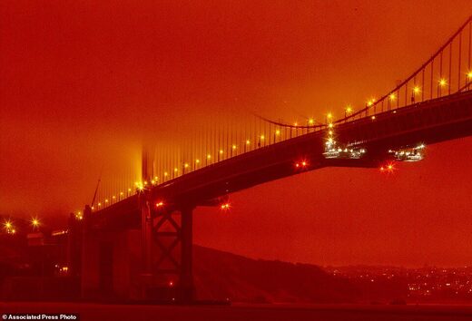 In this photo provided by Frederic Larson, the Golden Gate Bridge is seen at 11am Wednesday morning in San Francisco, amid a smoky, orange hue caused by the ongoing wildfires