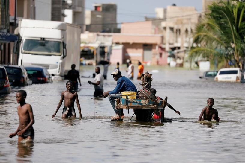 Residents walk through a flooded street after last week's heavy rains in Keur Massar, Senegal September 8, 2020.