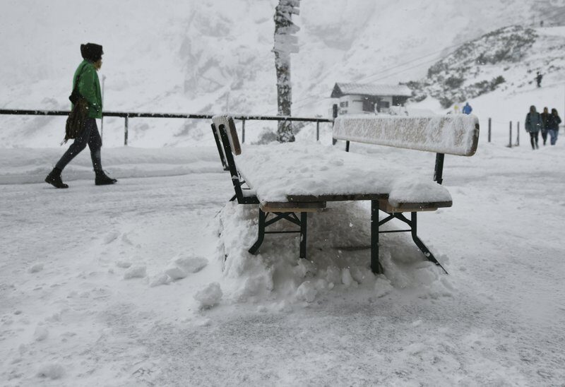 A woman walks across the snowy terrace of