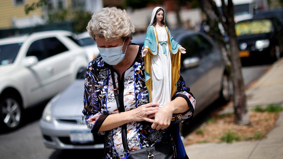 Click to enlarge woman holding Virgin Mary statue