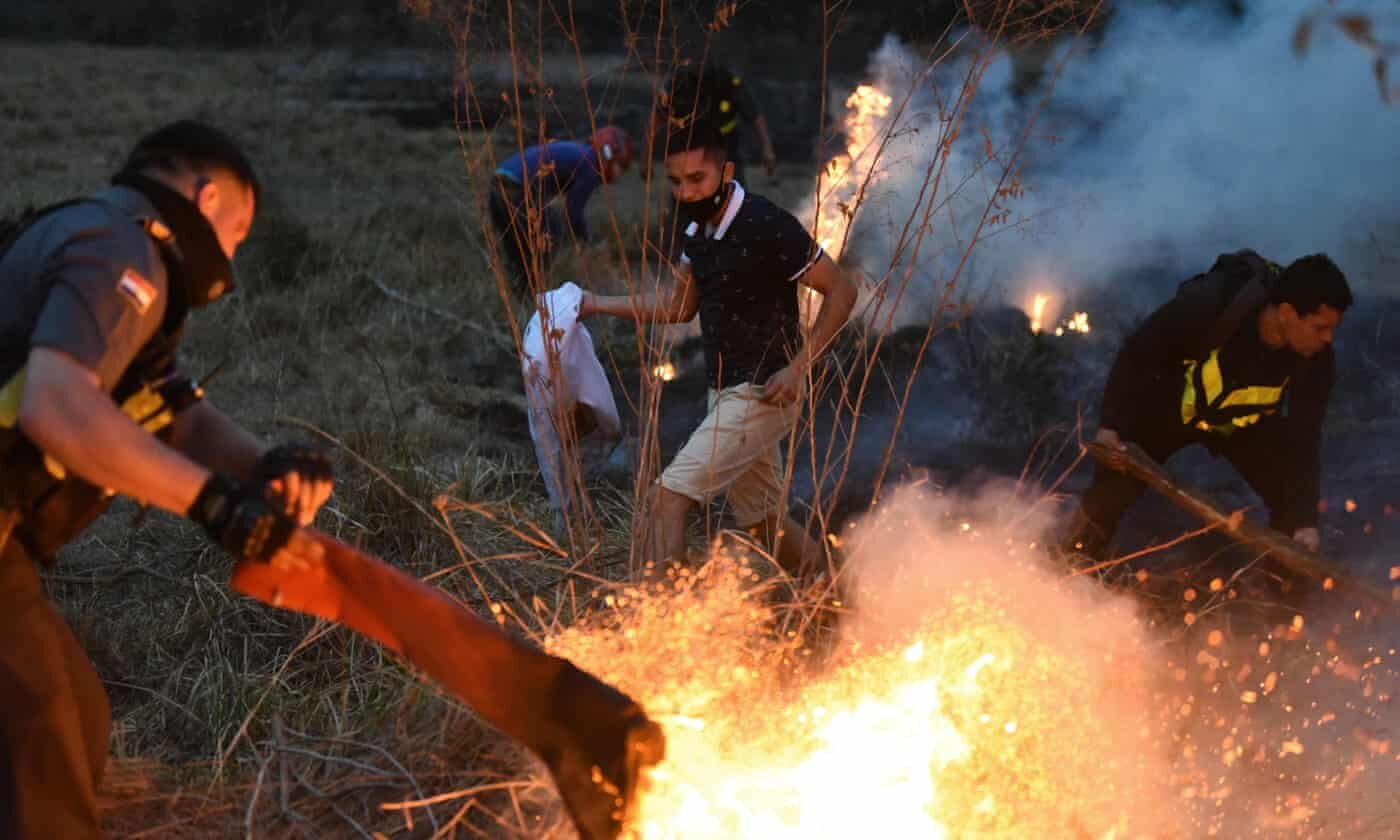 Click to enlarge Members of Paraguay’s highway patrol and local residents try to extinguish a fire on 27 September in San Bernardino, east of Asuncion, Paraguay.