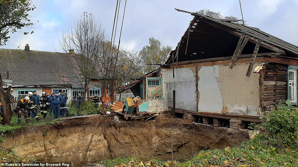 Click to enlarge An entire house was swallowed up when an enormous sinkhole suddenly opened in a Russian village. The attached house (pictured above) escaped the fate of its neighbour