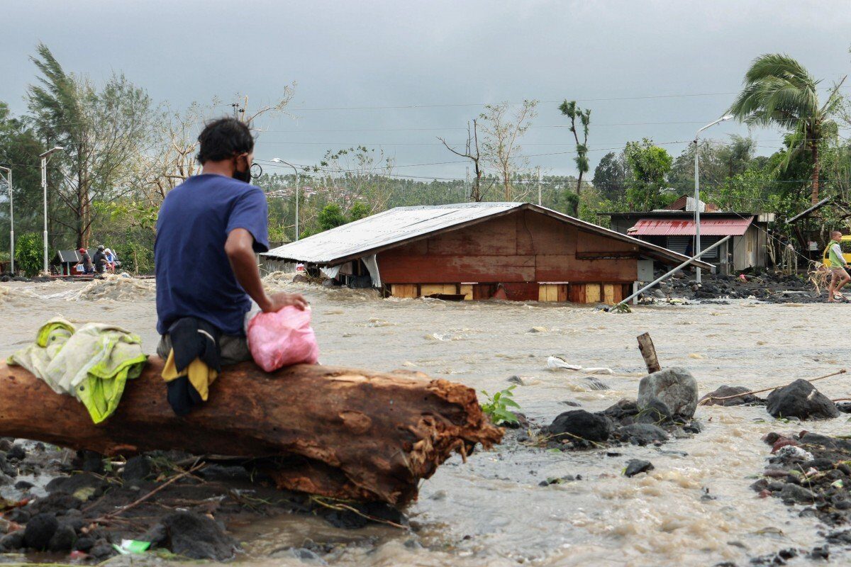 A man looks at his flooded house in Albay province after Typhoon Goni hit the Philippines.