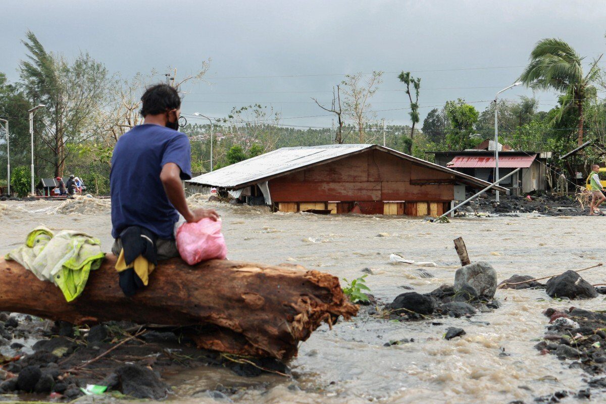 Click to enlarge A man looks at his flooded house in Albay province after Typhoon Goni hit the Philippines.