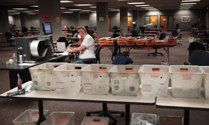 Click to enlarge Election officials count absentee ballots