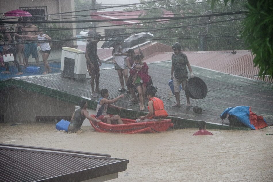 Rescuers assist residents as flood waters reach rooftops in Felicidad Village in Barangay Banaba, San Mateo, Rizal as Typhoon Ulysses batters Luzon Thursday.