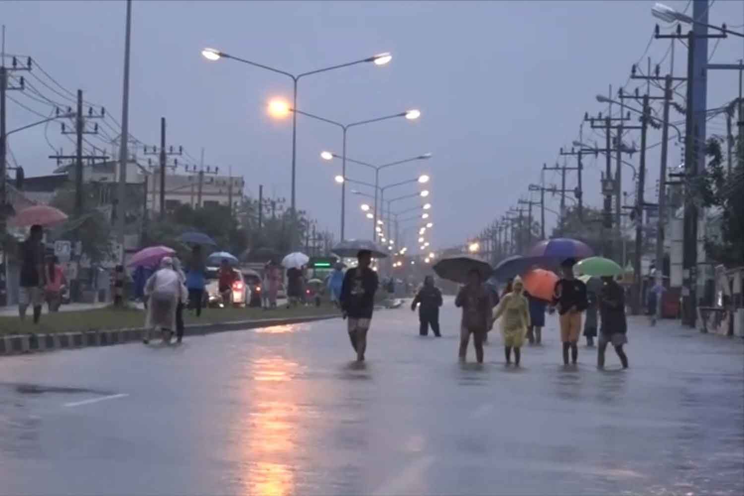 Click to enlarge Pedestrians cross a flooded street in Muang district of Songkhla following heavy rain on Monday night.