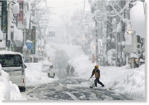 People remove snow on a street in Yuzawa,