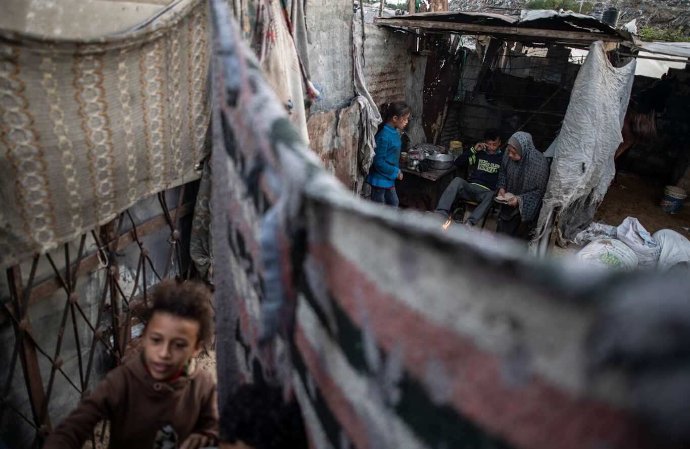 Click to enlarge A family prepares tea in a slum