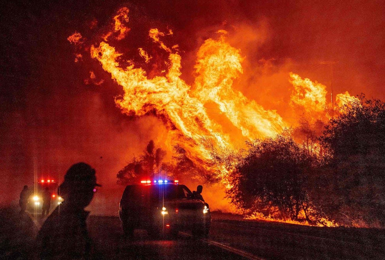 Click to enlarge A law enforcement officer watches flames launch into the air as fire continues to spread at the Bear fire in Oroville, California on September 9, 2020.