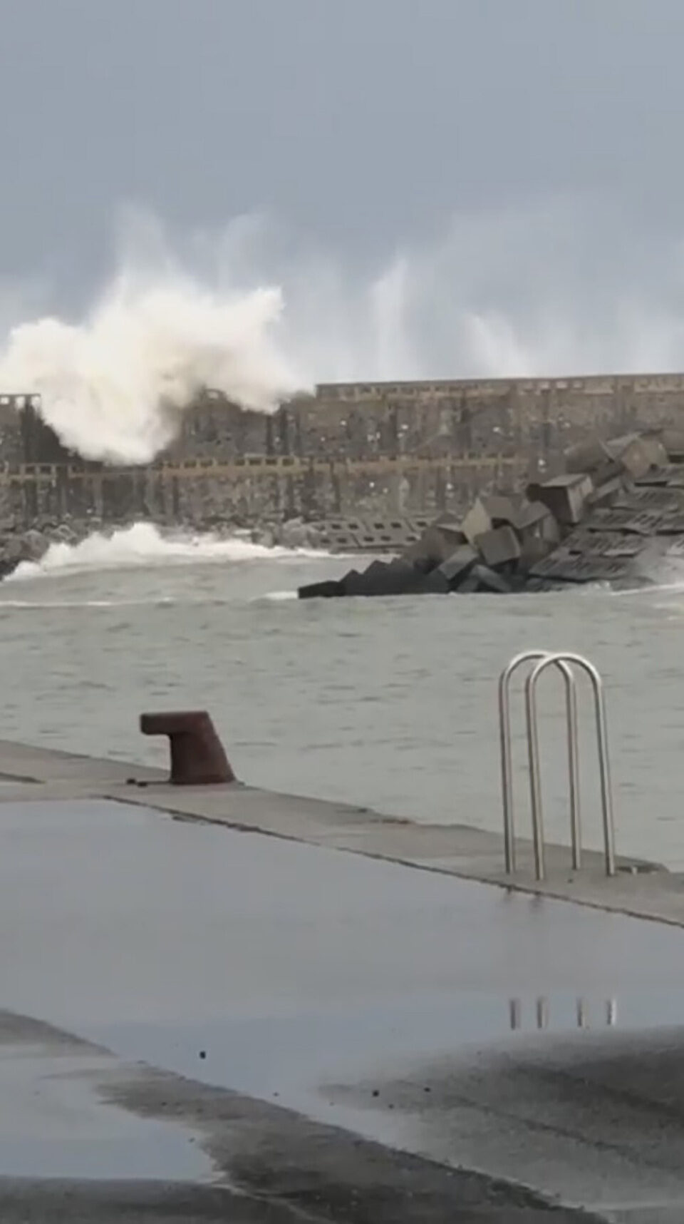 Click to enlarge The moment the wave crashes over the two runners