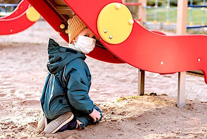 masked boy under slide