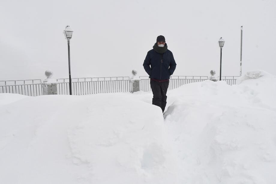 A person walks through the snow after a heavy snowfall at Pajares pass height in Castilla y Leon region, central-northern Spain.