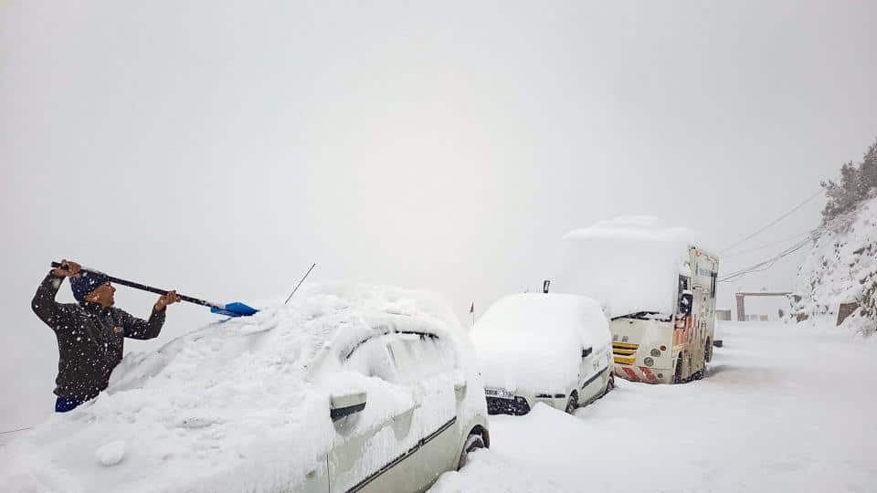 A man removes snow from a car after the town