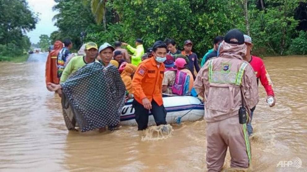 Click to enlarge January 15, 2021, by the Indonesian National Board for Disaster Management (BNPB) shows rescuers evacuating villagers by rubber boat in a flooded area in the Tanah Laut districts, South Kalimantan.