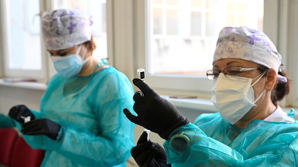 Click to enlarge Nurses prepare vaccines