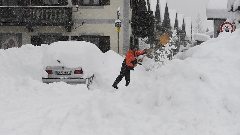Click to enlarge A man shovels his car free of snow after days of snowfall in Garmisch-Partenkirchen, southern Germany, Monday, Jan. 18, 2021. -