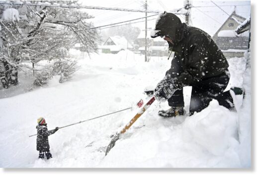 People remove snow from their house in Minakam