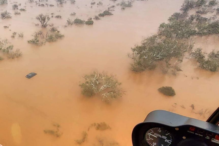 Justin Borg surveys a car swamped by floods