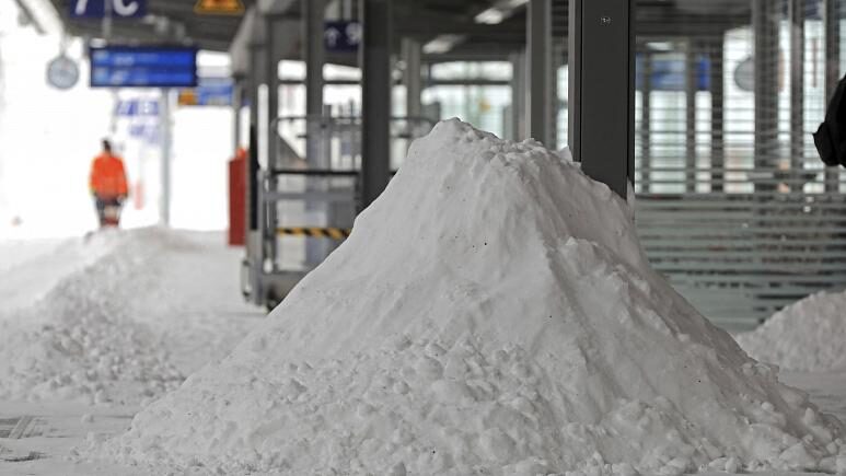 A Deutsche Bahn employee clears snow on
