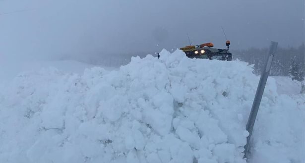 A tractor battles through the snow in a bid to clear the road