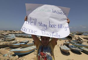  A Palestinian boy holds up a sign during a rally in support of the flotilla at Gaza's port yesterday