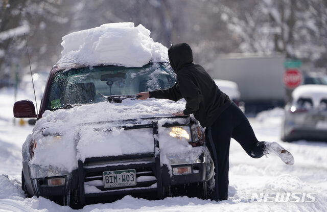 A Denver motorist works to clear
