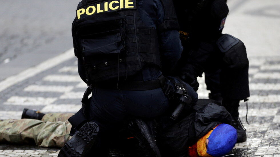 Police officers detain a demonstrator