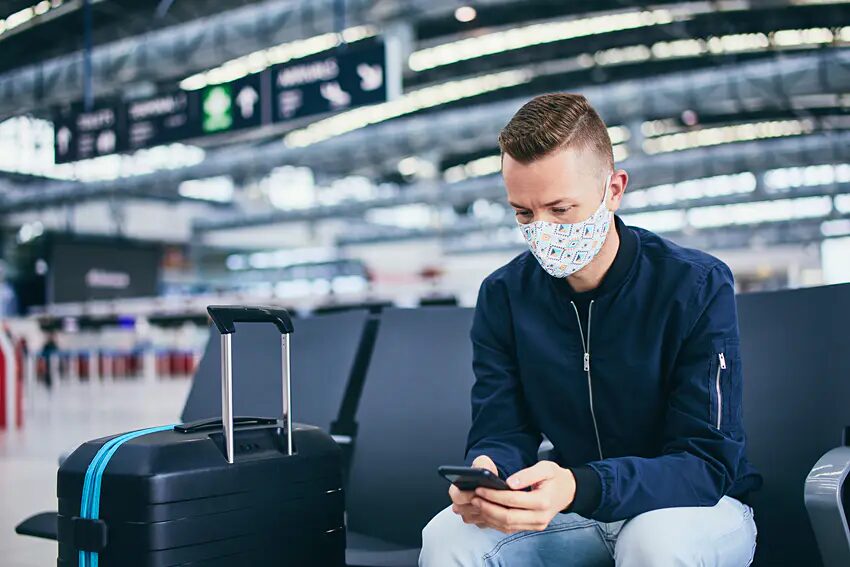 masked airport phone waiting