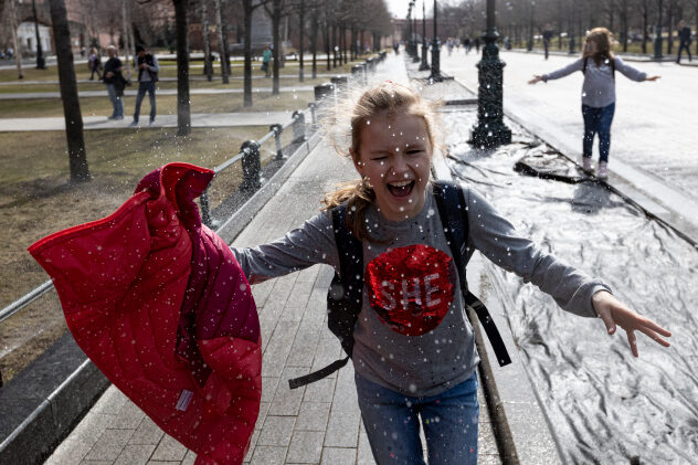 Click to enlarge A girl runs through a watering fountain cooling herself during a warm day near the Kremlin Wall in Moscow, Russia
